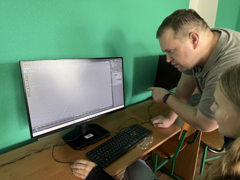 Керівник допомагає учасникові з моделлю.